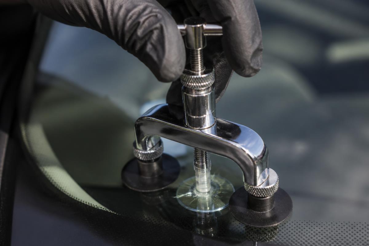 Technician injecting resin into a windshield rock chip